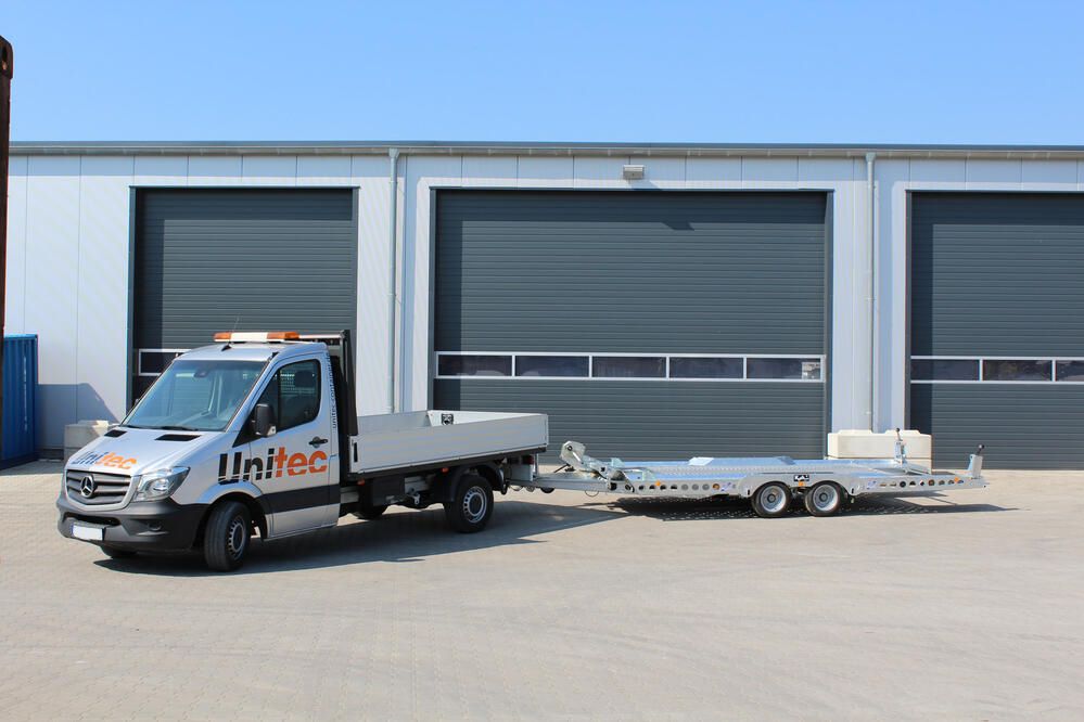 Mercedes-Benz Lkw mit Anhänger vor einer Lagerhalle